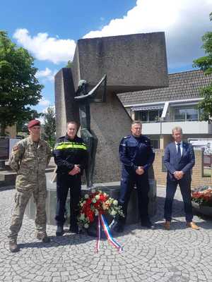 Polski Policjant, Policjanci Holenderscy i mężczyzna w garniturze stoja przy pomniku gdzie złożone są kwiaty
