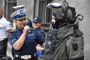 Policjantka prowadzi rozmowę z osobą ubraną w kombinezonie pirotechnicznym