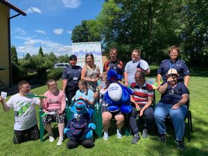 uczestnicy spotkania na pamiątkowej fotografii ze smokami policyjnymi i policjantkami