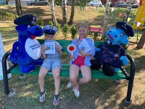 dziewczynki na ławeczce wraz z maskotkami policyjnymi