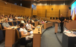 policjant prowadzi wykład w sali "aula"