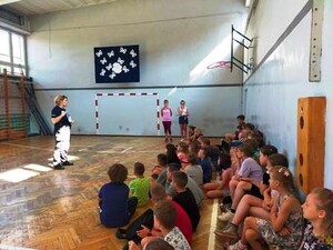 funkcjonariuszka przemawiająca do siedzących dzieci