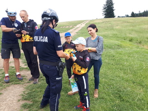 funckjonariuszka wręczająca ulotki dziecku