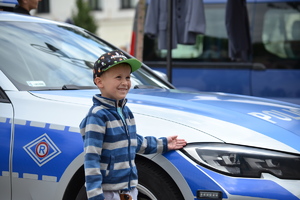 chłopiec pozujący do zdjęcia przy radiowozie policyjnym BMW