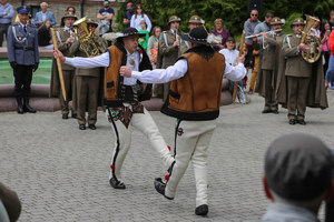 Orkiestra Reprezentacyjna Straży Granicznej. Dwóch mężczyzn tańczy w strojach góralskich