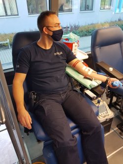 policjant w mobilnym punkcie oddaje krew