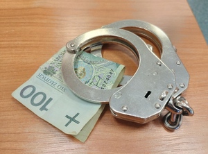 kajdanki i banknot 100 złotowy