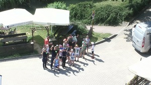 dzieci z półkoloni wraz z policjantką i straznikami machają do obiektywu