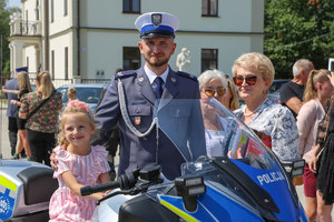 policjant z dzieckiem siedzącym na motocyklu