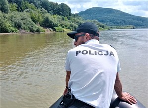 policjant posterunku wodnego prowadzi poszukiwania z łodzi