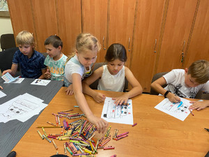 dzieci kolorują obrazki przedstawiające radiowóz