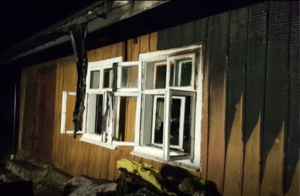 zniszczenia powstałe wskutek pożaru drewnianego budynku mieszkalnego - zniszczone okiennice i elewacja