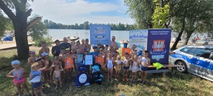 pamiątkowa fotografia uczestników akcji profilaktycznej z policjantami i maskotkami policyjnymi