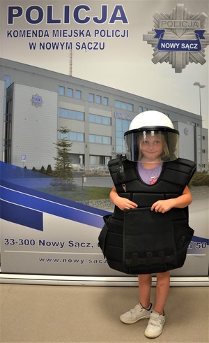 dziewczynka w policyjnym kasku ochronnym i kamizelce