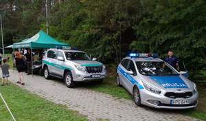 oznakowane radiowozy policji i straży granicznej w tle stoisko  KOSG