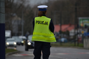 Policjantka ruchu drogowego nadzoruje ruch pojazdów na drodze