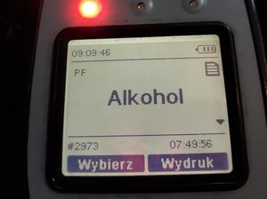 fragment elektronicznego urządzenia z widocznym kominukatem ALKOHOL na wyświetlaczu i zapaloną czerwoną lampką na obudowie