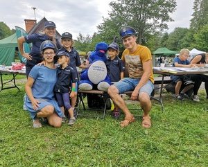 Policjantka  z uczestnikami  imprezy plenerowej w mundurkach policyjnych