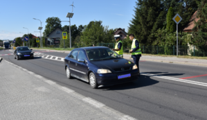 Policjant oraz Zastępca Dyrektora MORD w Tarnowie rozdają ulotki oraz elementy odblaskowe.