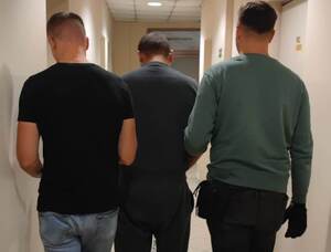 policjanci kryminalni prowadzą zatrzymanego