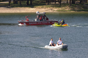 policjanci i strażacy w swoich łodziach na wodzie