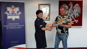 Obok Komendanta Powiatowego Policji w Gorlicach stoi mężczyzna – p. Tomasz Kiełtyka, który w ręce trzyma okolicznościowy list gratulacyjny
