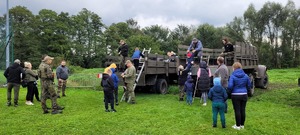 uczestnicy imprezy w Jankowicach podczas wsiadania do cieżarówek wojskow...