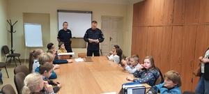 Komendant komisariatu oraz policjantka rozmawiają z dziećmi