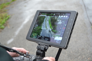 Wyświetlacz urządzenia sterującego dronem na którym widać obraz z kamery zamontowanej na dronie