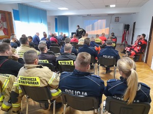 policjanci, strażacy, ratownicy medyczni siedzący na sali konferencyjnej podczas ćwiczeń aplikacyjnych