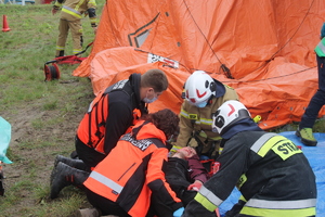 ratownicy medyczni i strażacy udzielający pomocy rannemu mężczyźnie