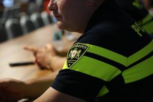 Zbliżenie na żółto niebieską koszulkę gruzińskiego policjanta