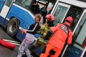 Ratownicy wyciągają osoby z autobusu
