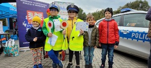 pamiątkowa fotografia z dzieci ubranych w kamizelki odblaskowe, czapki policyjne oraz dzieci trzymają lizaki i krzyżówki