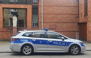 radiowóz zaparkowany przed budynkiem parafii
