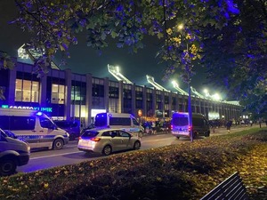 Pora nocna, policyjne radiowozy stoją wzdłuż ulicy prowadzącej na stadion