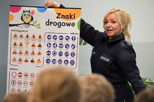 Policjantka prezentująca tablicę edukacyjną ze znakami drogowymi
