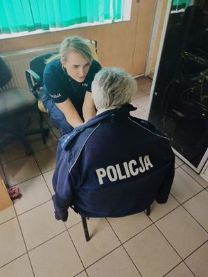 Policjantka rozmawia z seniorką. Seniorka ma założoną bluzę z napisem Policja