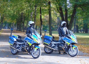 Nowe motocykle dla oświecimskiej drogówki dwaj policjanci stoją przy motocyklach w tle jesienne drzewa
