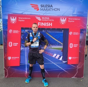 dzielnicowy Jakub Ciągło po maratonie Silesia 2022 w  w stroju sportowym z medalem w ręku