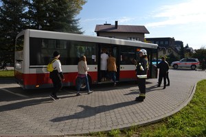 ososby z oddziału wsiadają do autobusu, obok strażak