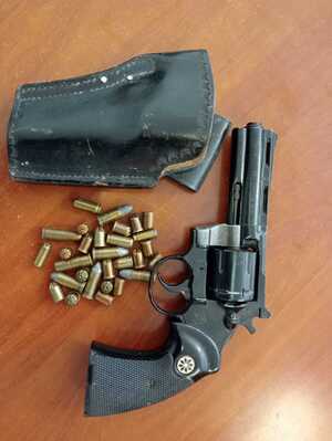 rewolwer obok kabura oraz naboje