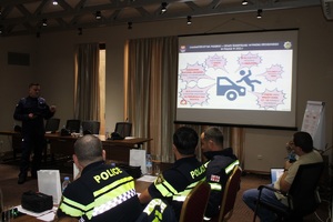 Policjant z polski omawia wypadki drogowe przed rzutnikiem