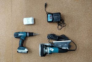 odzyskana lamelownica oraz wkrętarka wraz z ładowarkami. Sprzęt w kolorze czarno-niebieskim leży na podłodze