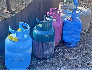 Osiem butli gazowych w różnych kolorach. Ujawnione i zabezpieczone przez policjantów
