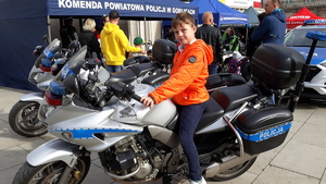 Na policyjnym motocyklu siedzi młody chłopiec