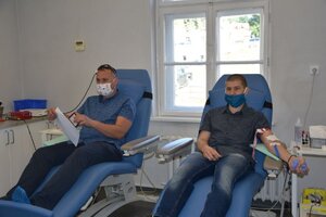 dwóch policjantów na fotelu podczas oddawania krwi