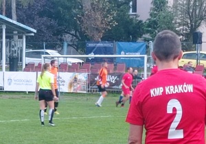 Zdjęcie z meczu drużyny krakowskich policjantów, na pierwszym planie zawodnik w koszulce z napisem KMP Kraków