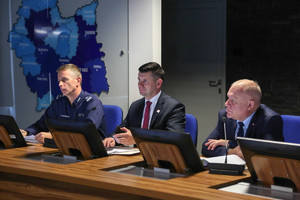 Pierwszy Wojewoda Wicemarszałek i Naczelnik Wydziału Ruchu Drogowego siedzą przy stole głównym na posiedzeniu