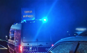 noc policyjny radiowóz błyskające lampy na dachu radiowozu napis Uwaga wypadek